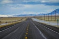 People on road trip drive their car down highway leading across the prairie.