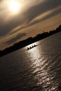People rowing boat at sunset