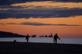 people running, searching with metal detector and walking a dog, on the beach Royalty Free Stock Photo