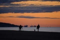 people running, searching with metal detector and walking a dog, on the beach Royalty Free Stock Photo