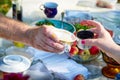 People& x27;s hands with beautiful cups of tea at the outdoor table on a sunny summer day. A joint tea party in the