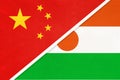 China or PRC vs Niger national flag from textile. Relationship between Asian and African countries