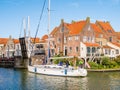 People on sailboat and open drawbridge to old harbour of Enkhuizen, Noord-Holland, Netherlands