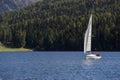 People sailing an yacht on a mountain lake
