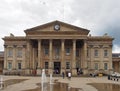 people in saint georges square huddersfield in front of the facade of the historic victorian train station