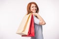 People, sale and consumerism concept - Attractive woman with red hair over white background holding shopping bags