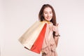 People, sale and consumerism concept - Happy asian woman over white background holding shopping bags