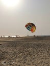 People in the sea beach enjoying and paragliding