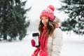 Young woman with hot drink in tumbler in winter