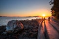 Tourists and Locals Enjoying a Stunning Sunset from the Seawall in Stanley Park in Vancouver Canada