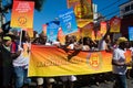 People are seen with banners and posters during the neighborhood Carnival