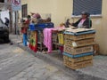 People selling chickens kept in small cages at the pavement next to the street