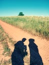 People shadows on old dusty road with ferric red soil.  Shadows Royalty Free Stock Photo