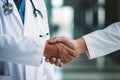 People shaking hands closeup, handshake between doctor and patient, blur room interior background