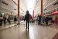 People shoppers inside a modern shopping centre mall walking. Man with bag