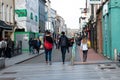 People shopping on Oliver Plunkett St, one of the city`s main streets for stores, street performers, restaurants, and busy city. Royalty Free Stock Photo