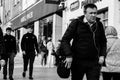 People shopping on Patrick Street in Cork, the main street for stores, street performers, restaurants; photographed in monochrome.