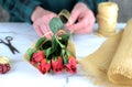 close up of causcasian florist woman wrapping red rosebuds in burlap Royalty Free Stock Photo