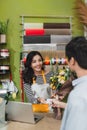 People, shopping, sale, floristry and consumerism concept - happy smiling florist woman making bouquet for and man or customer at Royalty Free Stock Photo