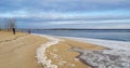 People on the shore at the beginning of winter on the freezing Volga on a Sunny day Royalty Free Stock Photo