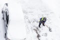 People shoveling snow near car on parking. Snow clearance after a heavy snowfall