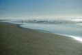 People silhouetted on the beach fishing and playing as the surf come in Royalty Free Stock Photo