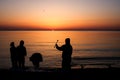 People are silhouetted on the beach during a summer sunrise Royalty Free Stock Photo