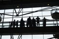 People silhouetted on a walkway in a building near the windows Royalty Free Stock Photo