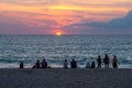 People silhouettes on the beach at the sunset