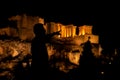 People silhouettes in the foreground, with Acropolis night view at the background