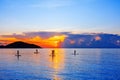 People silhouettes stand SUP paddle boarding, sea sunset beach, active young man woman surfing paddling board, ocean sunrise Royalty Free Stock Photo