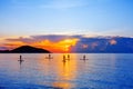 People silhouettes stand SUP paddle boarding, sea sunset beach, active young man woman surfing paddling board, ocean sunrise Royalty Free Stock Photo