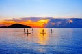 People silhouettes stand SUP paddle boarding, sea sunset beach, active young man woman surfing paddling board, ocean sunrise Royalty Free Stock Photo