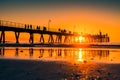 People silhouettes walking along jetty at sunset