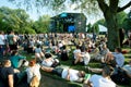 People sit on the grass and have rest on outdoor party of music festival