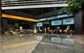 People sit outside a Caffe Nero and Leon food retail chain cafe in central London