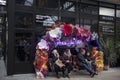 People sit on a restaurant bench under an artificial flower arch in Spitalfields Market