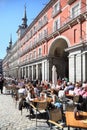 People sit at tables in cafe at Plaza Mayor