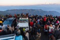 People are sitting on the car with crowd for seeing the first light of new year`s day at dawn with mountain villages.
