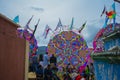 People sitting in the cemetery looking at giant china paper kites,