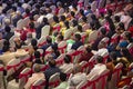 People are sitting on chairs and watching a function in a hall