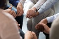 People sitting in circle holding hands at group therapy session Royalty Free Stock Photo