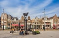 People sitting at the cow sculpture on the Koemarkt square in Purmerend