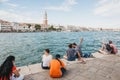 People sitting on the embankment of Grand Canal in Venice, Italy.