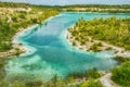 People sitting enjoy a picnic and relax by the crystal clear water of the Karlstrup Kalkgravis lake by the white chalky beach