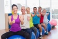 People sitting on exercising balls gesturing thumbs up Royalty Free Stock Photo