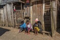 People sitting infront of a poor woodhouse in the village Andasibe, Madagascar Royalty Free Stock Photo