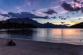 People sitting by the lake Wakatipu and watching beautiful sunset in Queenstown Royalty Free Stock Photo