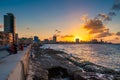 People sitting on the malecon seawall in Havana during a beautiful sunset