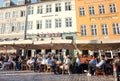 People sitting at outdoor restaurants of Nyhavn, eating and drinking outside in popular leisure area Royalty Free Stock Photo